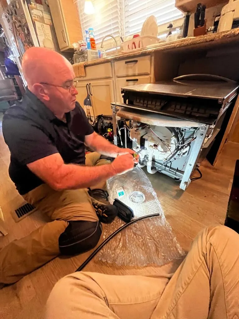 Technician installing a built-in dishwasher