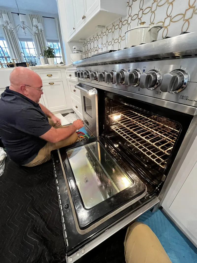 Technician servicing a professional-style range oven