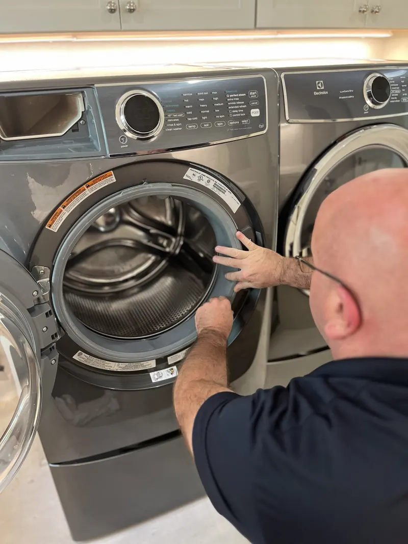 Technician checking a front-load washer door seal